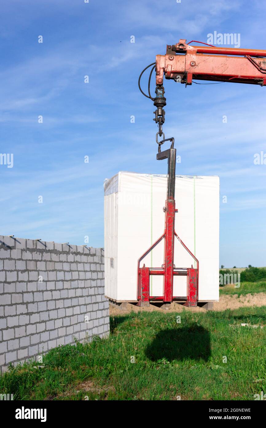 Unloading building blocks from a truck using a crane. Hydraulic ...