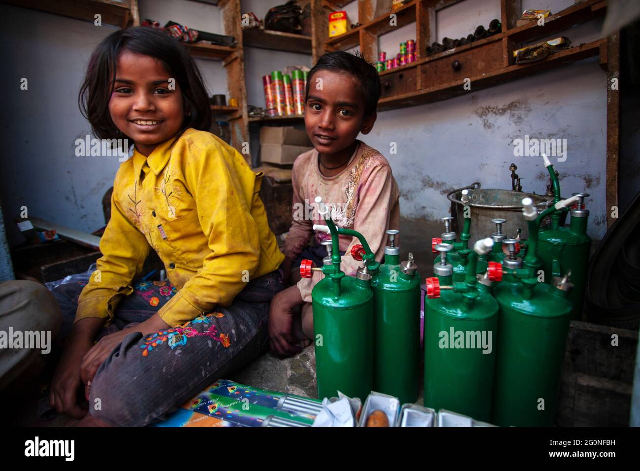 Brother and sisters selling small pumps for playing holi Stock Photo