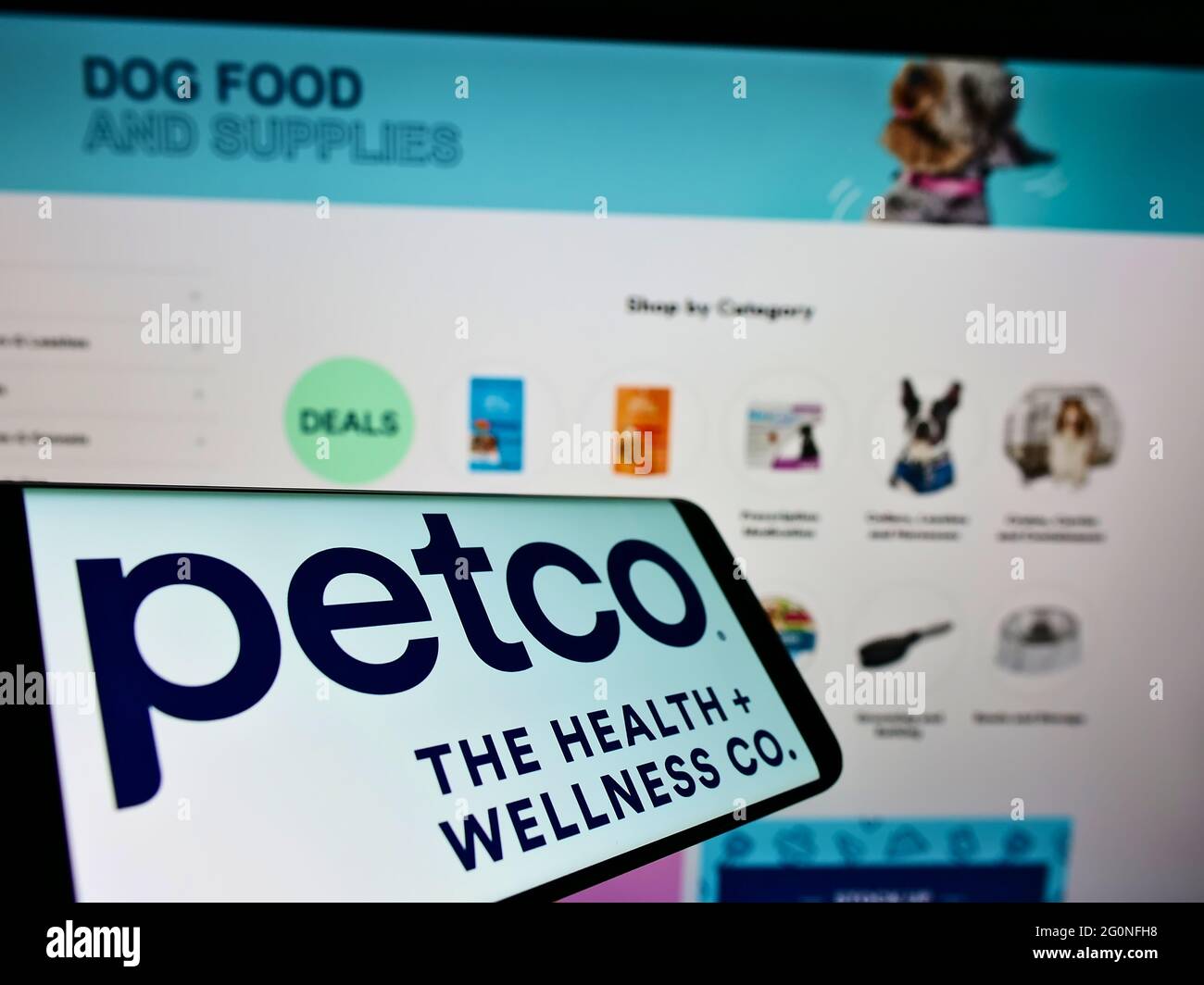 Cellphone with logo of American retailer Petco Health and Wellness Company on screen in front of website. Focus on center-right of phone display. Stock Photo