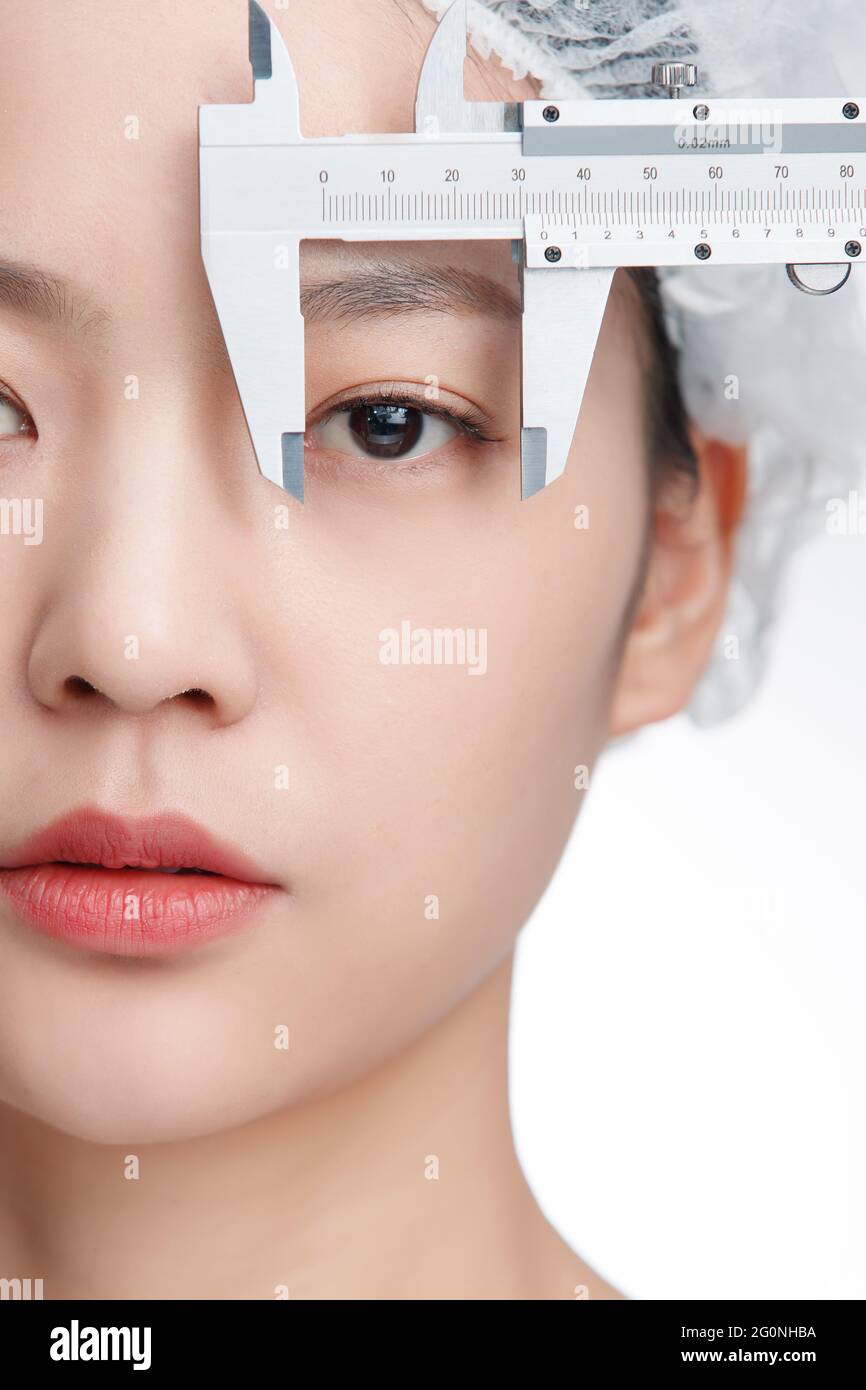 Young women face is measured with a caliper Stock Photo Alamy