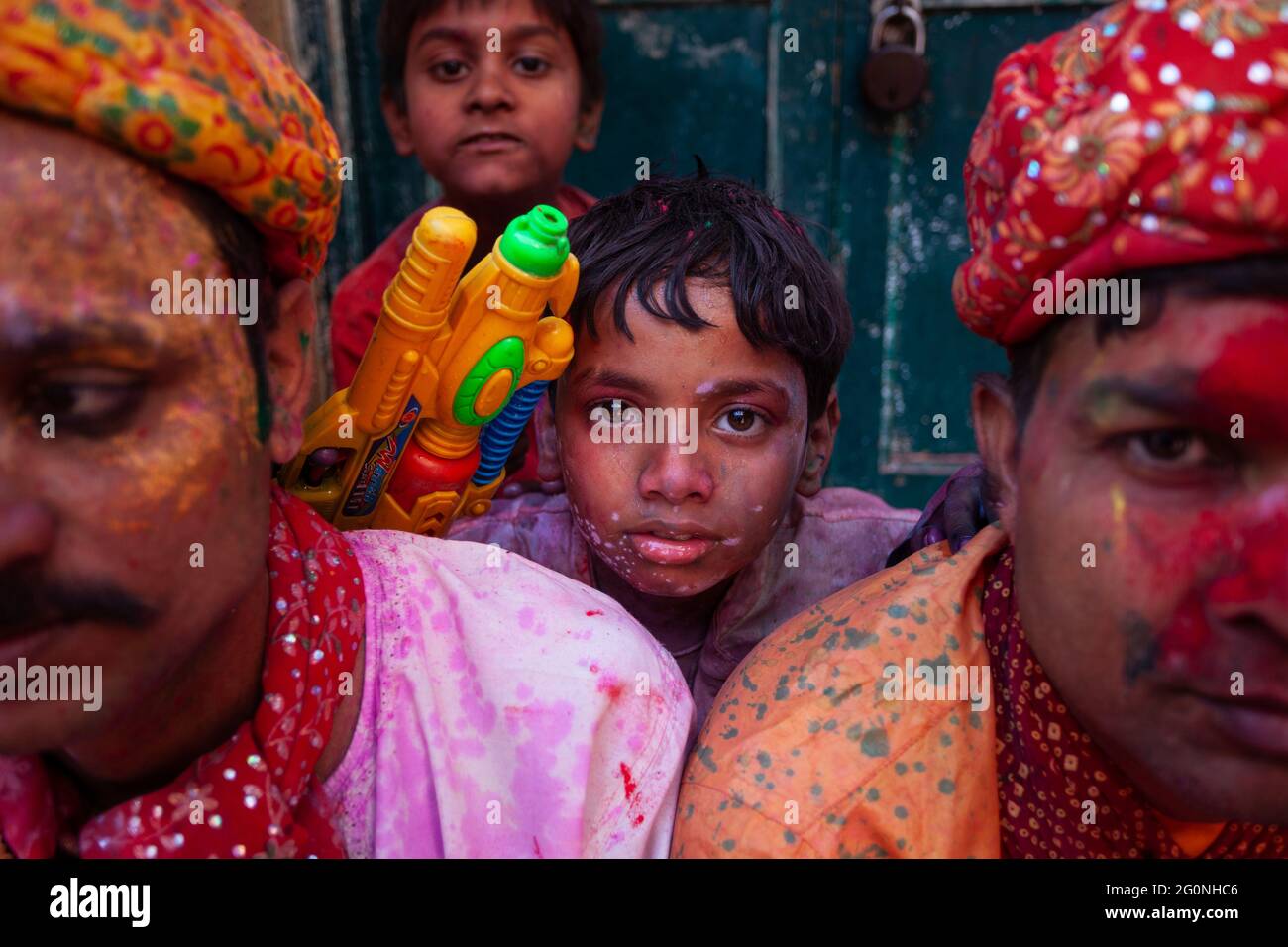 Indian middle aged man with children with face smudged with colour in holi festival and looking at camera Stock Photo