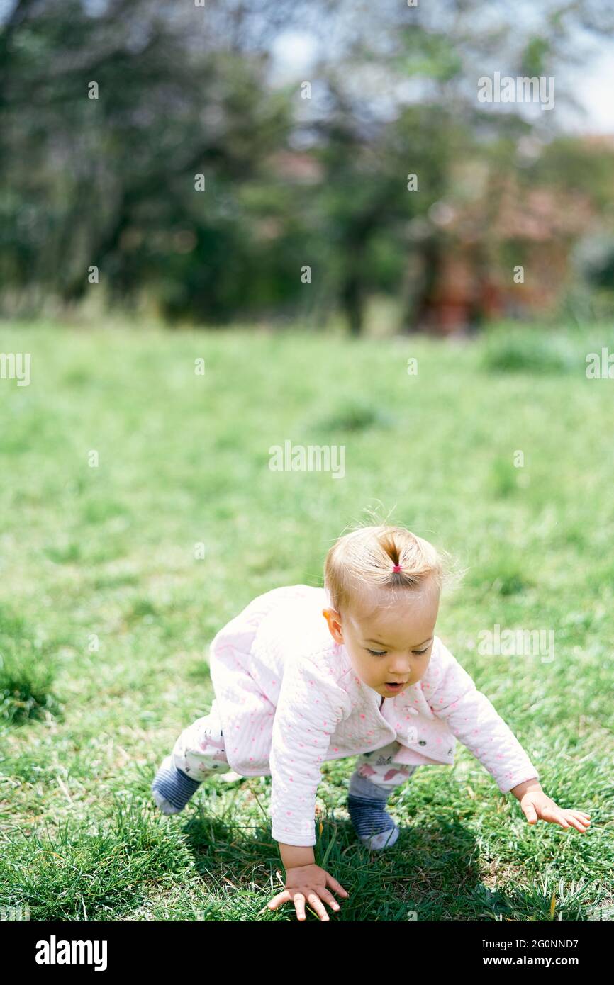 Little child girl falls on the grass Stock Photo Alamy