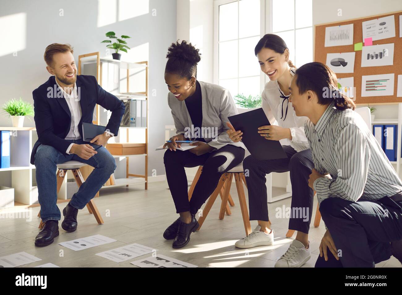 Happy young people working on project, analyzing data and having fun in group meeting Stock Photo