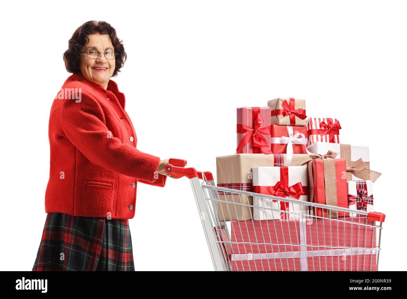 Grandma pushing a shopping cart with presents and looking at the camera isolated on white background Stock Photo