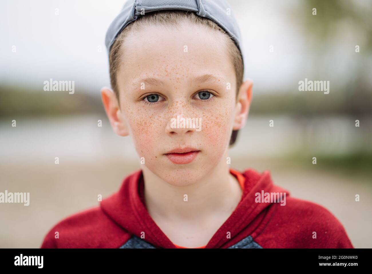Close-up portrait of teenage serious boy with freckles on his face, shallow depth of field Stock Photo