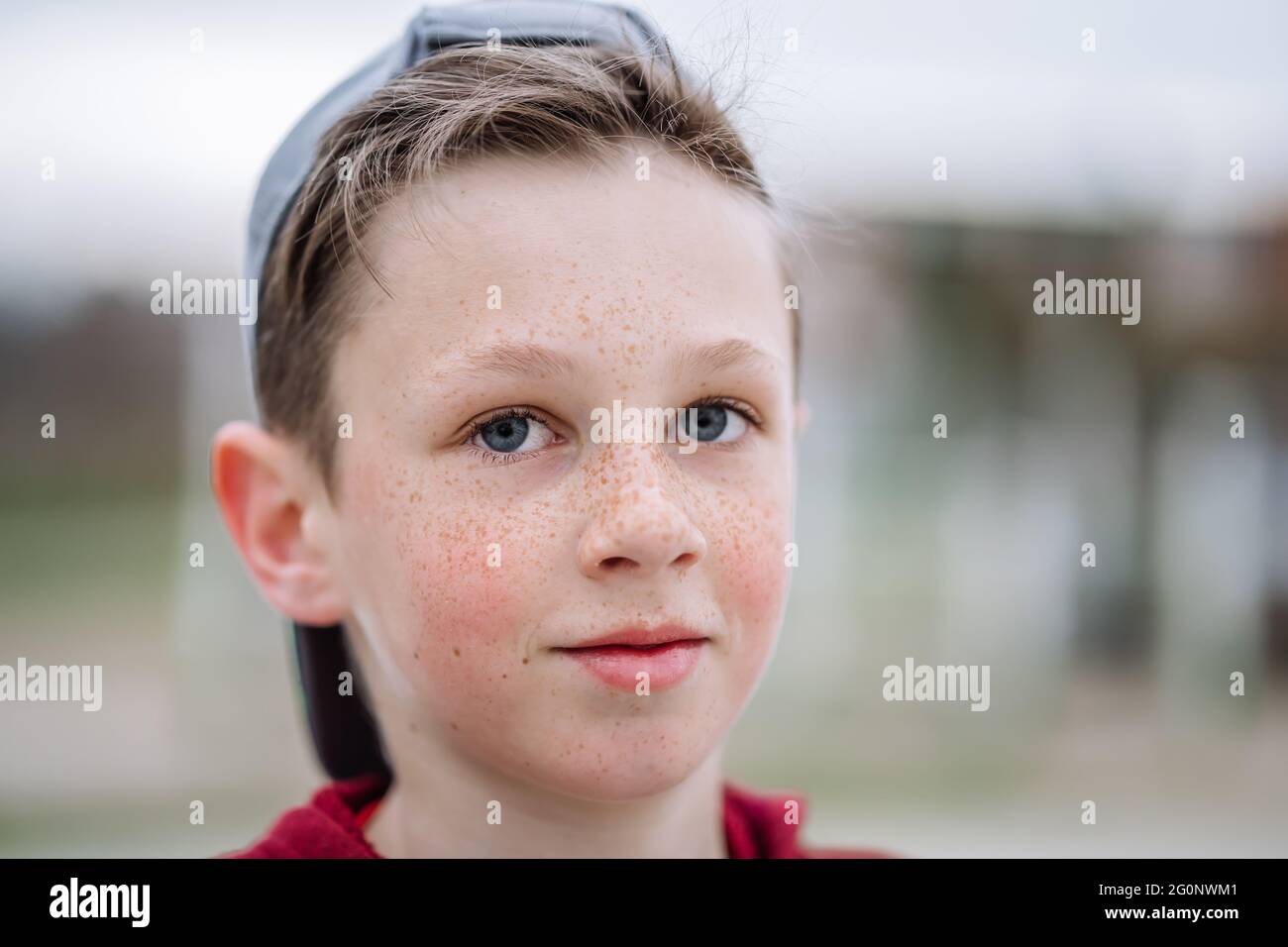 Close-up portrait of teenage smiling boy with freckles on his face, shallow depth of field Stock Photo