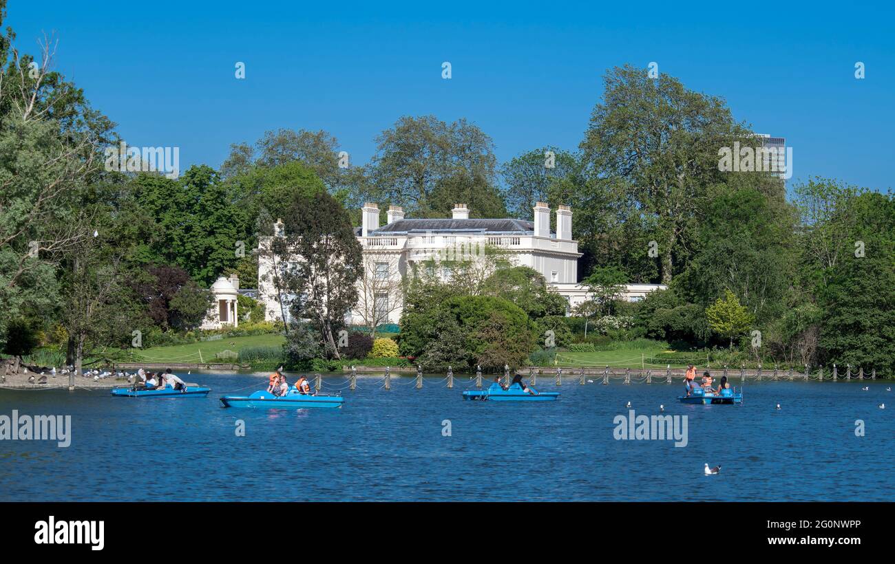 The boating lake with paddle boats and The Holme a grand mansion Regents Park London Stock Photo