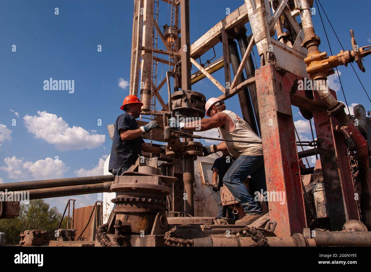 Roughnecks add a section of pipe to an oil well in the Elgin Field along the Oklahoma and Texas border.. High-pressure fracturing opened up new and old oil fields in Texas and helped move the country away from using coal. Stock Photo