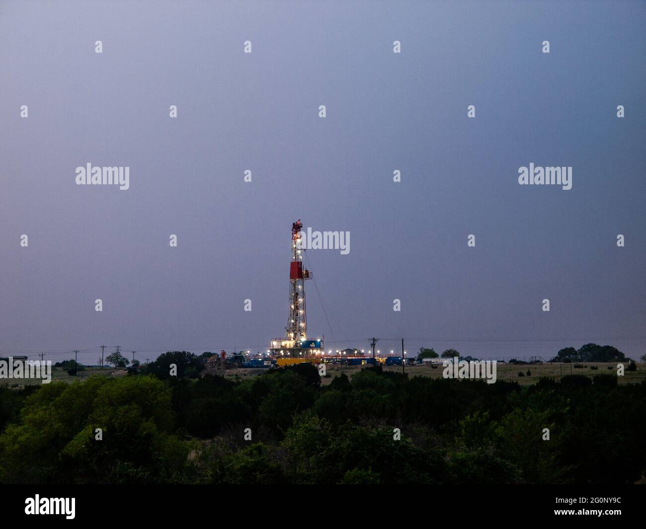 Lights shine on an oild rig drilling for natural gas in south Texas Eagle Ford field south of San Antonia. High-pressure fracturing opened up new and old oil fields in Texas and helped move the country away from using coal. Stock Photo