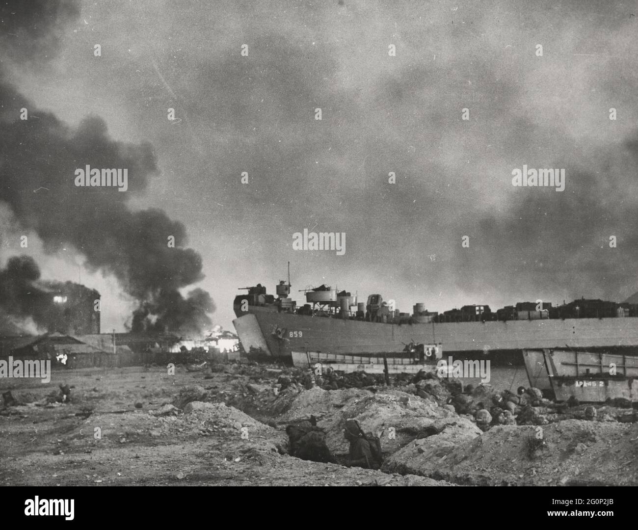 Waterfront at Inchon blazes as Marines pour in from landing craft and an LST pushes up on the shore, all her guns firing in th great amphibious flanking move against the North Koreans, September 15, 1950 Stock Photo