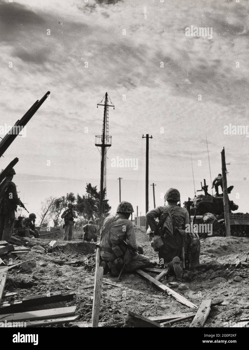 An element of a Marine Tank Infantry Team pause on shell torn ground just long enough to establish contact with their command post and report the progress of their advance against the retreating North Koreans Stock Photo