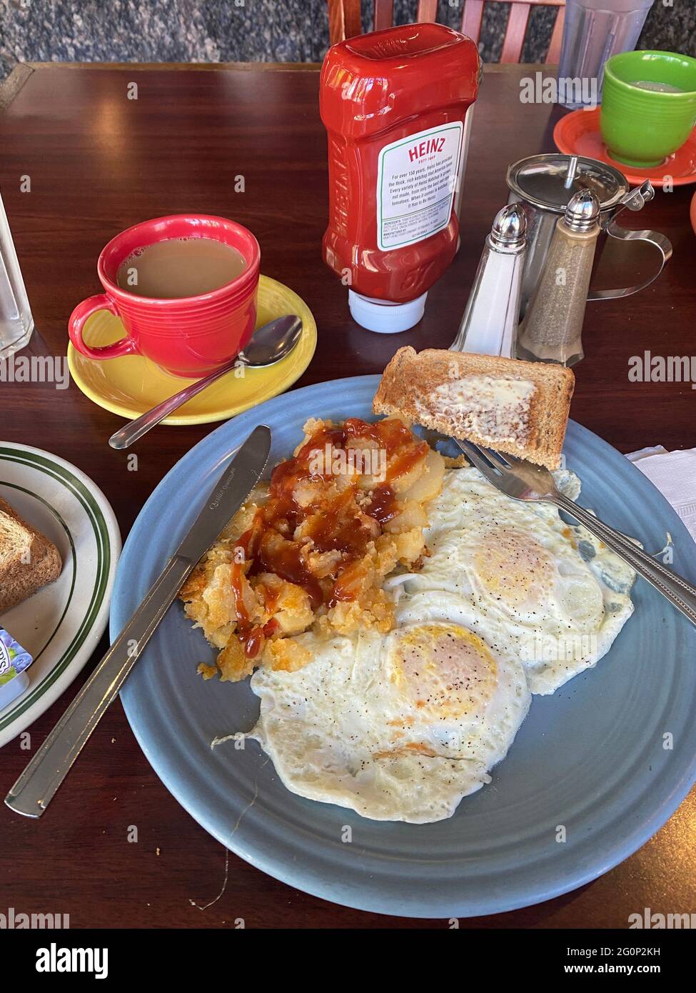 DIner breakfast of eggs over easy, home fries, toast and coffee is an