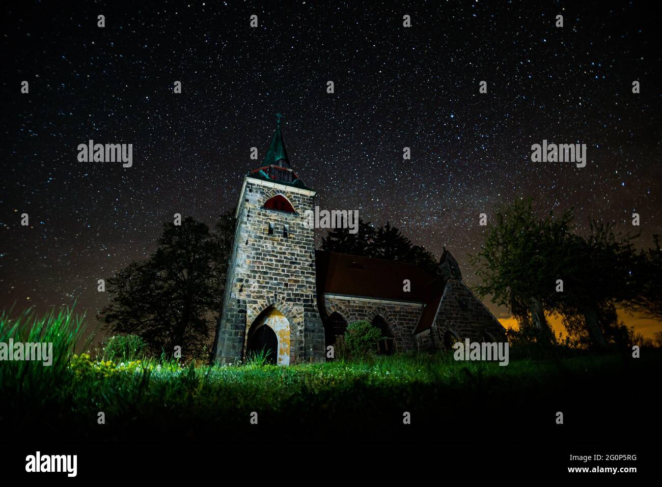 Church Of The Divine Heart Of The Lord with night sky full of stars in background in small village Borovnicka, Czech republic Stock Photo