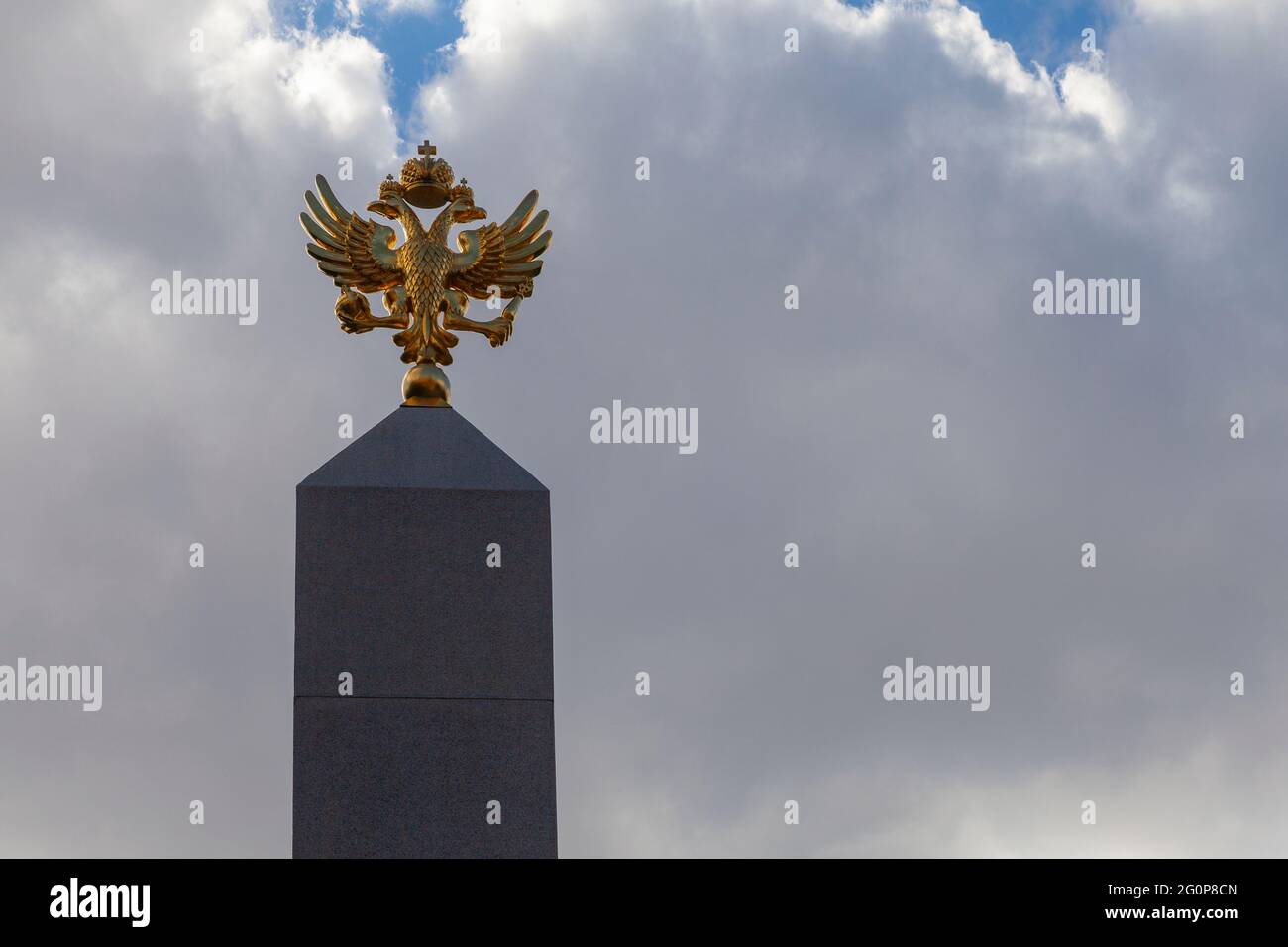 Coat of arms of Russia golden double-headed eagle at the top of the granite pyramid. Stock Photo