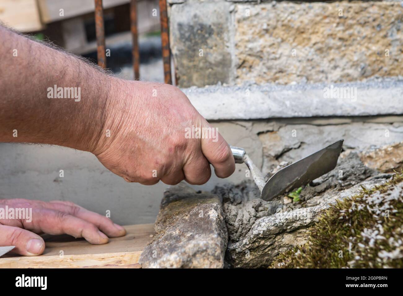 A person processing concret cement on a do it yourself garden project Stock Photo