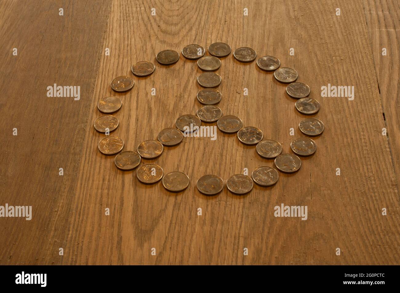 A Peace Sign Made Out of Quarter on an Oak Background Stock Photo