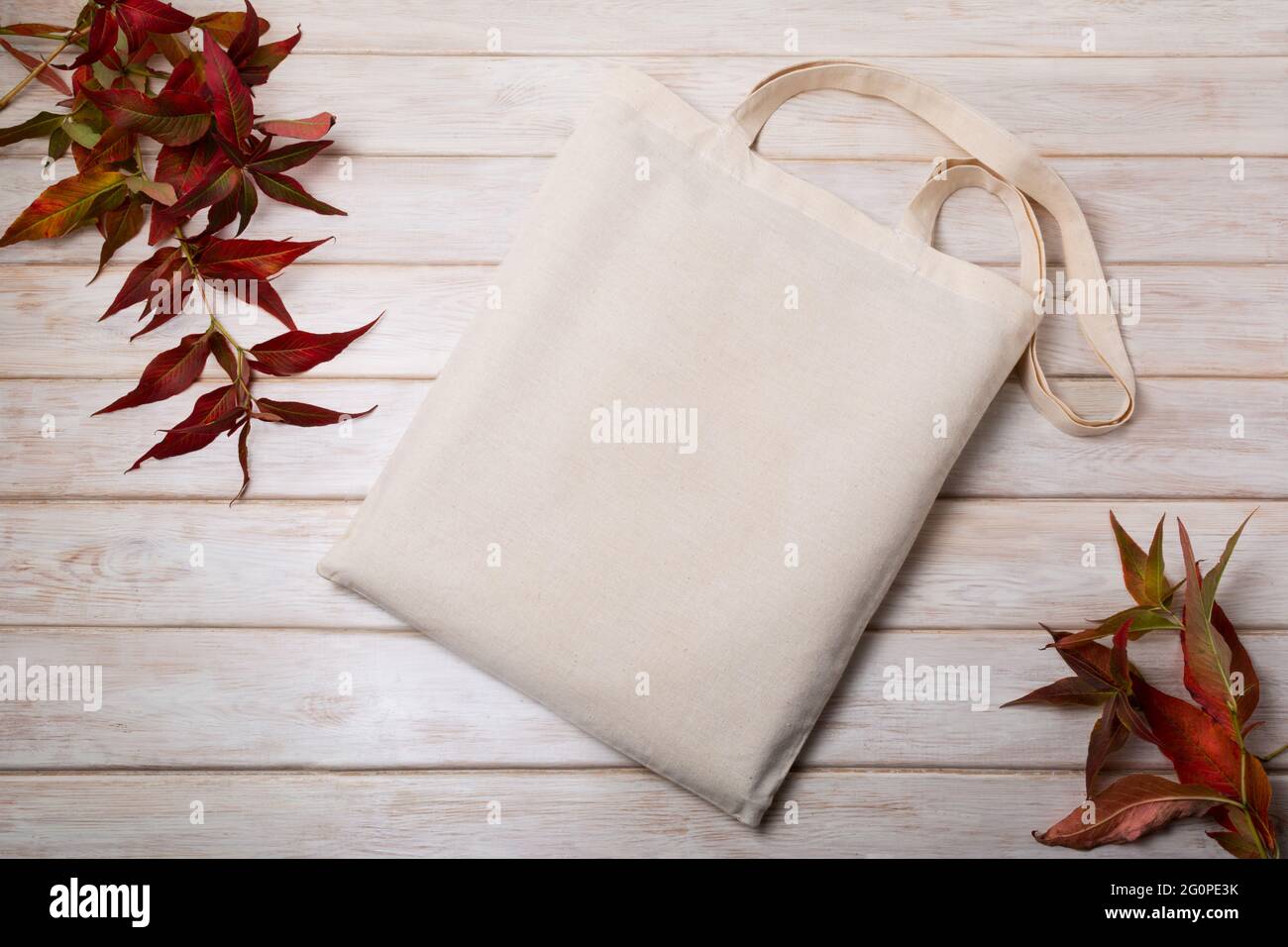 Canvas tote bag mockup with red leaves wild grass. Rustic linen shopper bag mock up for branding presentation Stock Photo