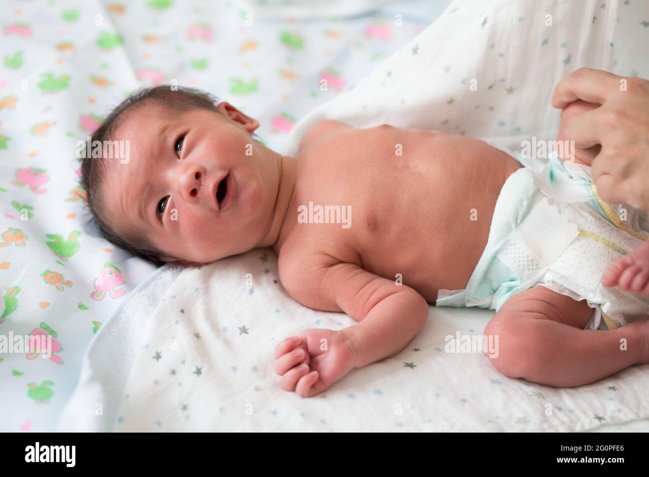 Asian baby boy is wearing diapers after bathing on bed, Ten days old