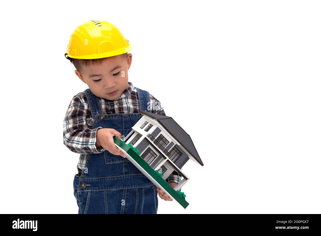 Asian Thai baby boy wearing an engineer suit with hard hat and holding a sample house isolated on white background, Construction worker of real estate Stock Photo