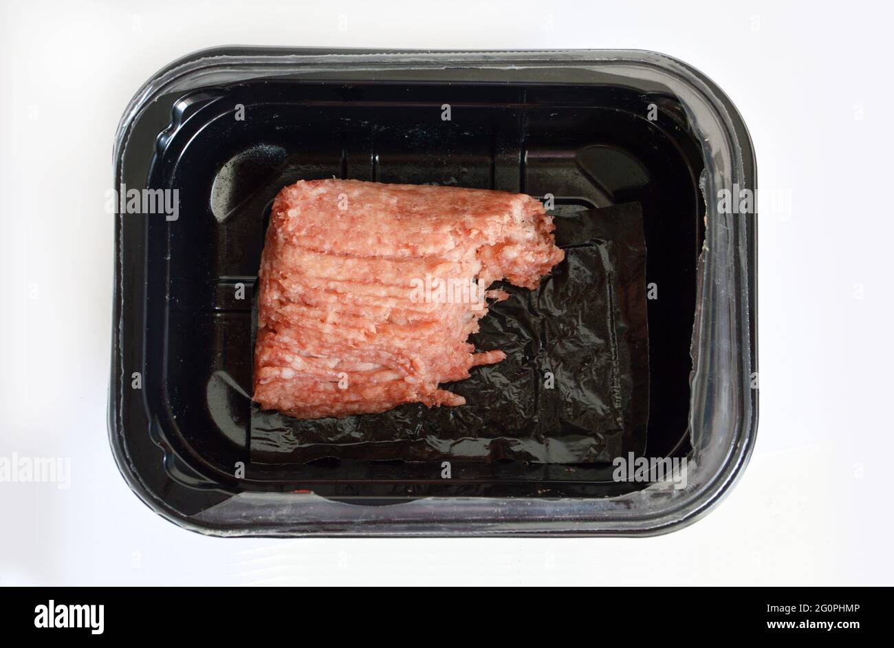 Minced pork in plastic container against white background Stock Photo