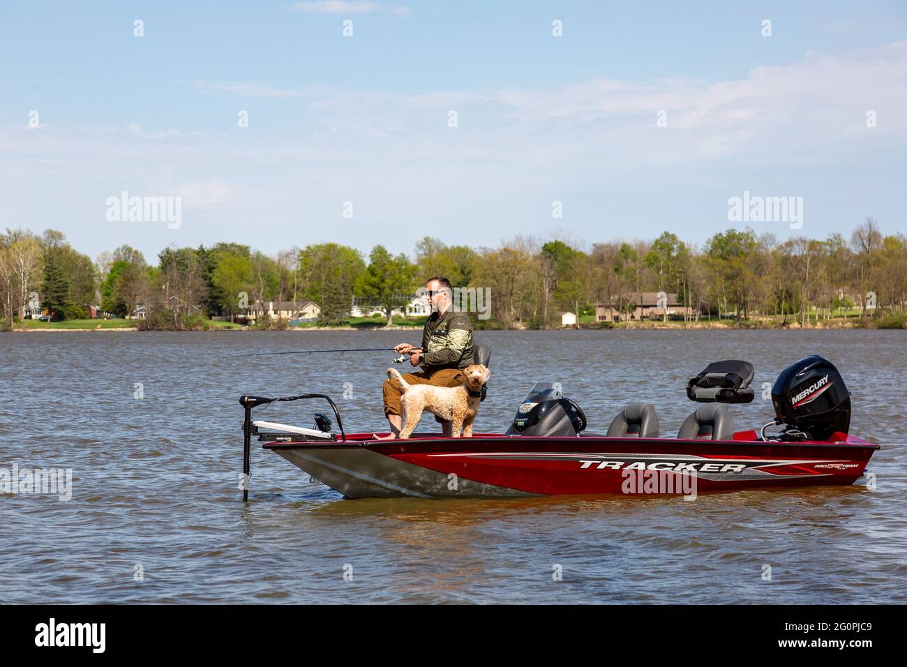 A man accompanied by his dog fishes the waters of the Cedarville Reservoir in Leo-Cedarville, Indiana, USA. Stock Photo