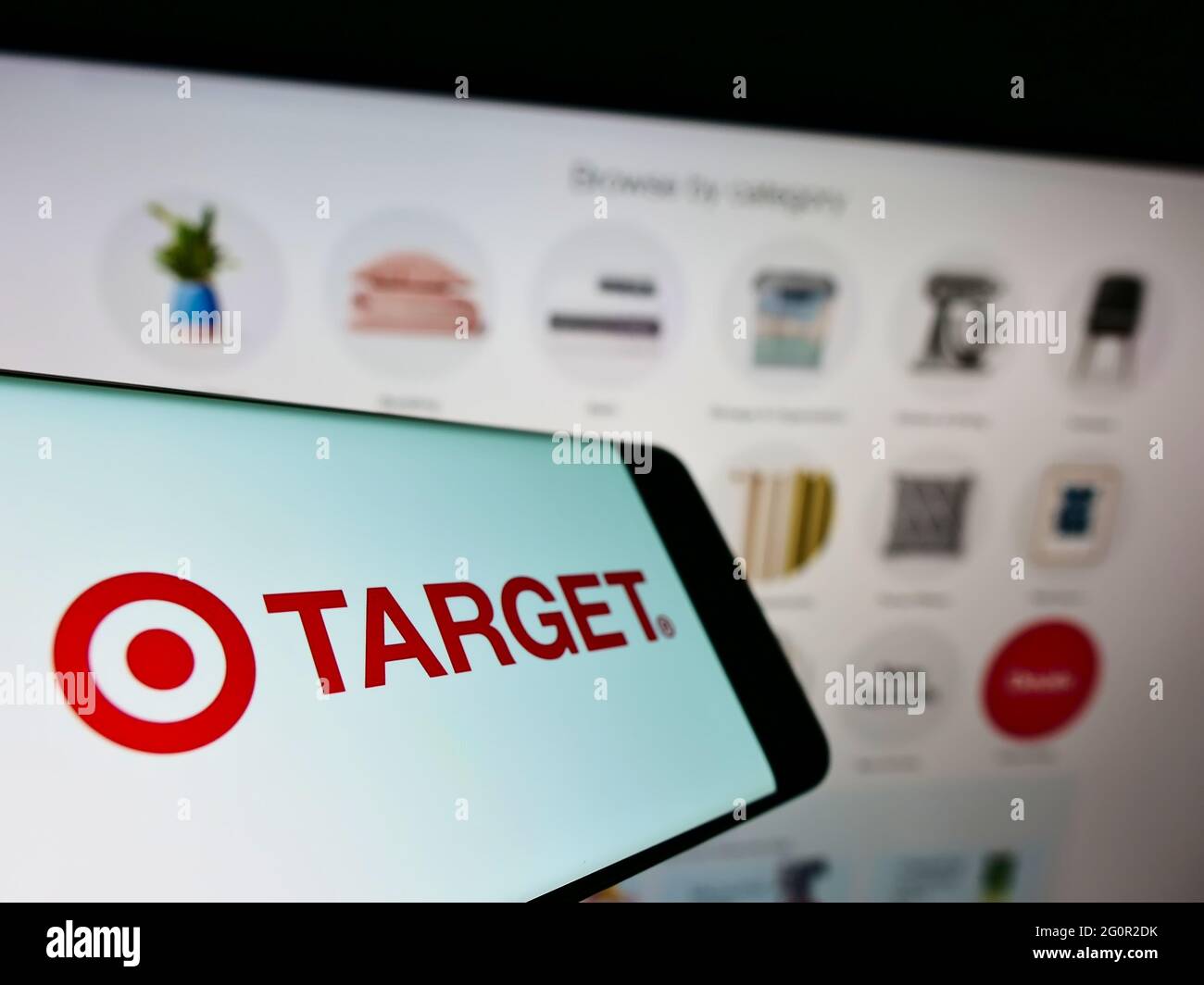 Cellphone with logo of US retail company Target Corporation on screen in front of business website. Focus on center-left of phone display. Stock Photo