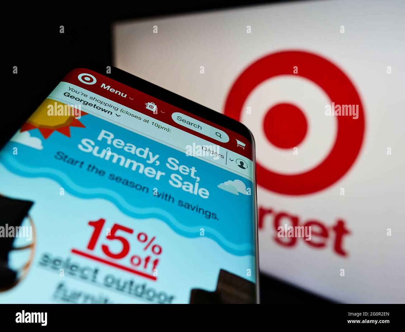 Mobile phone with website of US retail company Target Corporation on screen in front of business logo. Focus on top-left of phone display. Stock Photo