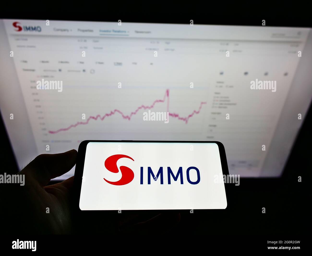 Person holding smartphone with logo of Austrian real estate investment