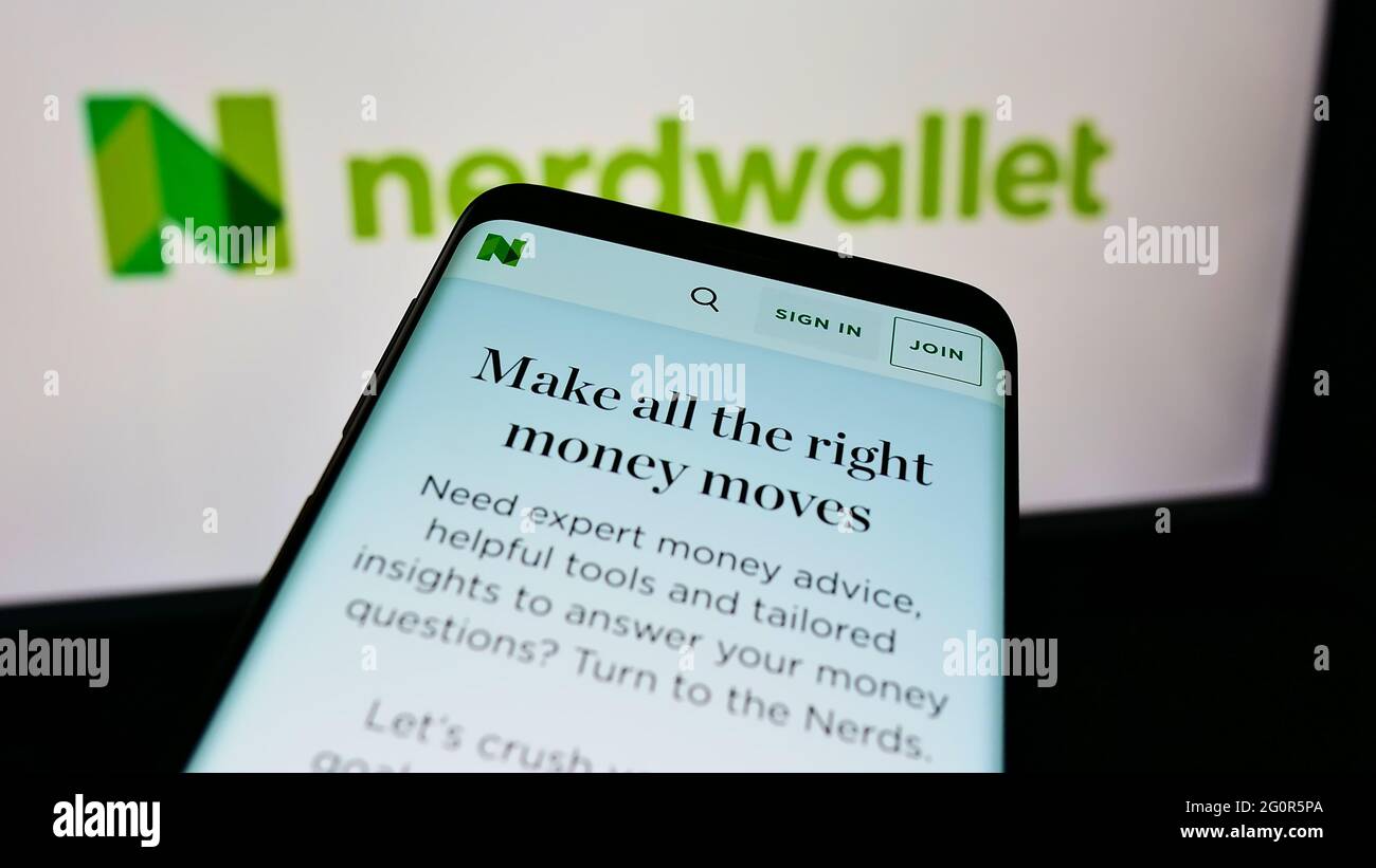 Smartphone with website of US personal finance company NerdWallet Inc. on screen in front of business logo. Focus on top-left of phone display. Stock Photo