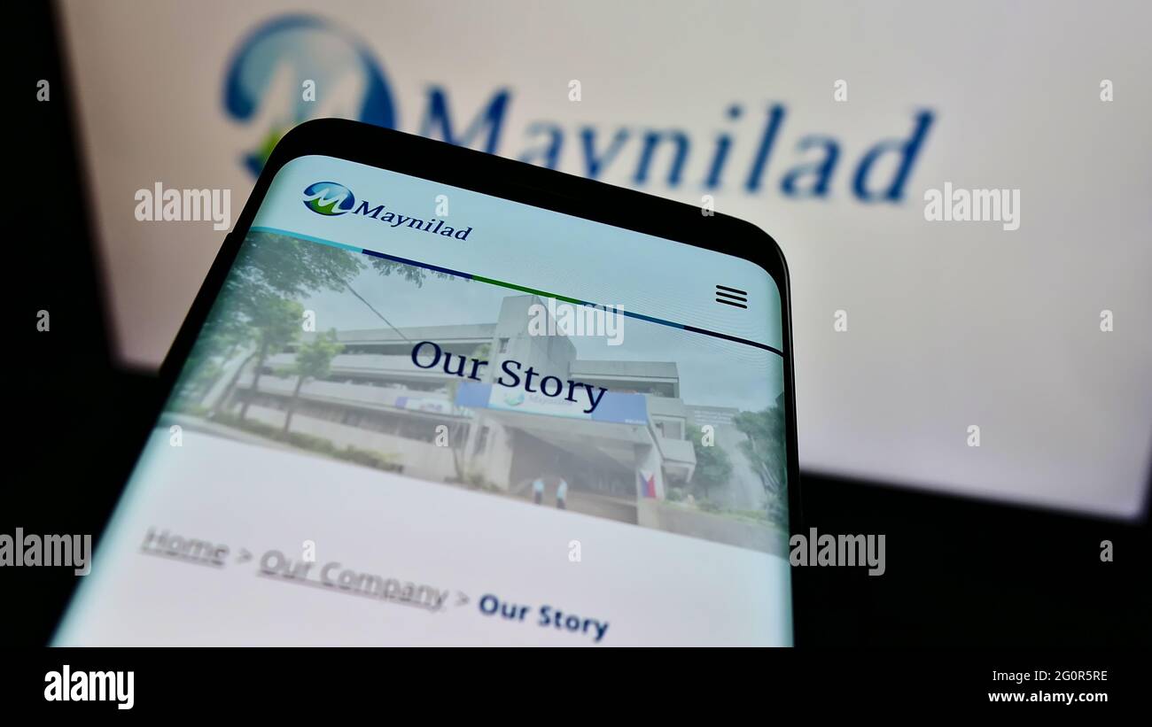 Mobile phone with website of Philippine company Maynilad Water Services Inc. on screen in front of business logo. Focus on top-left of phone display. Stock Photo
