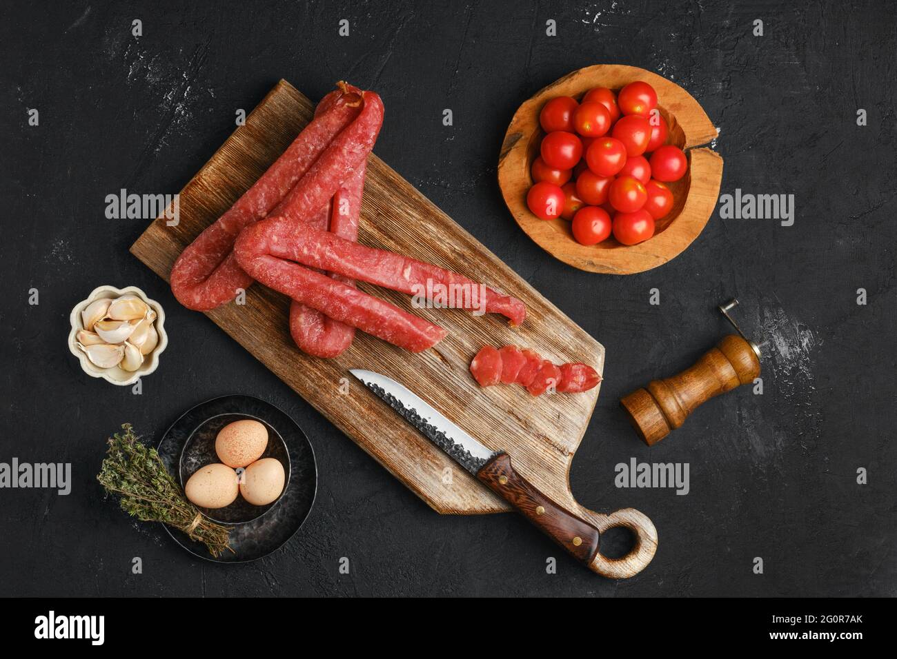 Air dried turkey sausage. Rustic lunch with eggs and tomato. Stock Photo