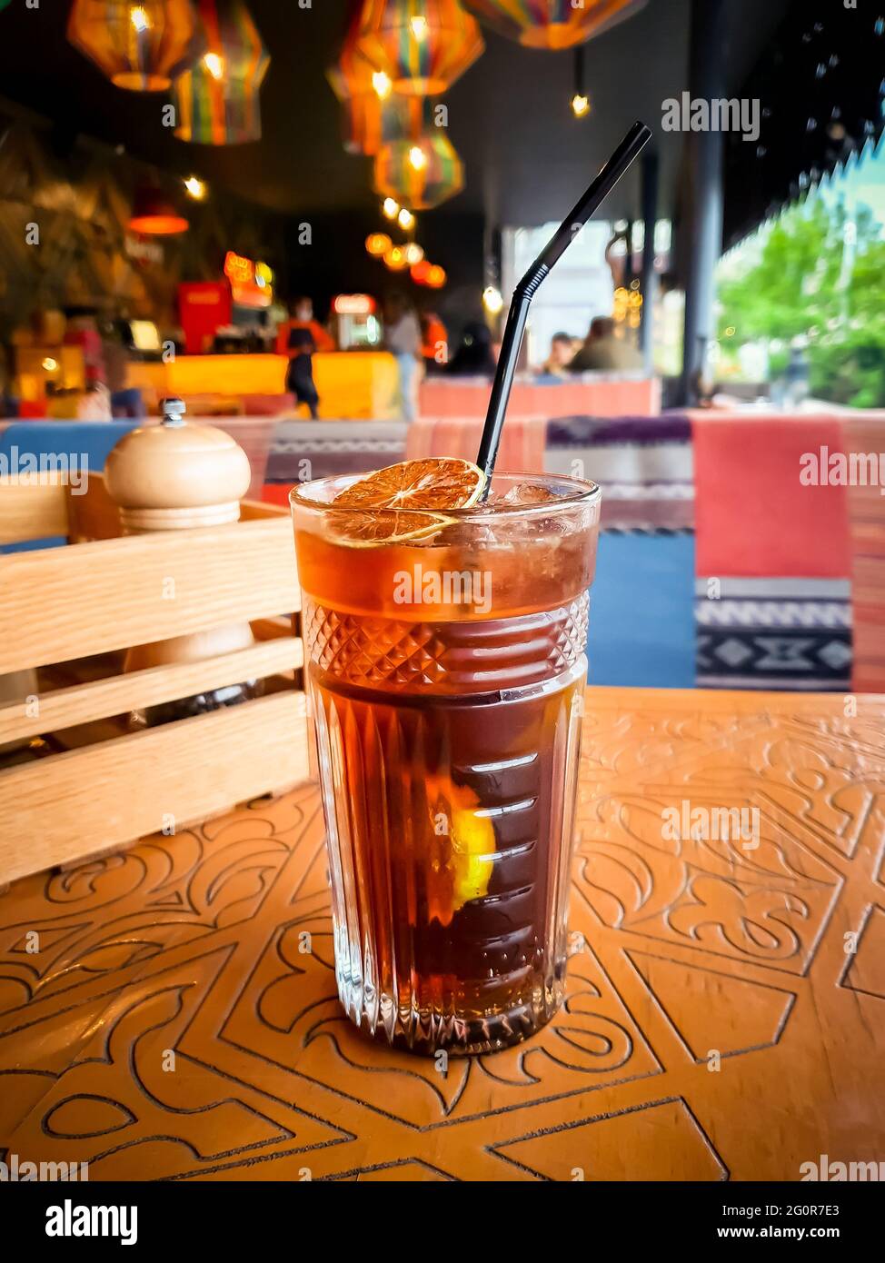 Long Island iced tea, alcoholic mixed drink amber colored, highball, alcohol beverage on the table in restaurant, cocktail in a glass in a summer cafe Stock Photo