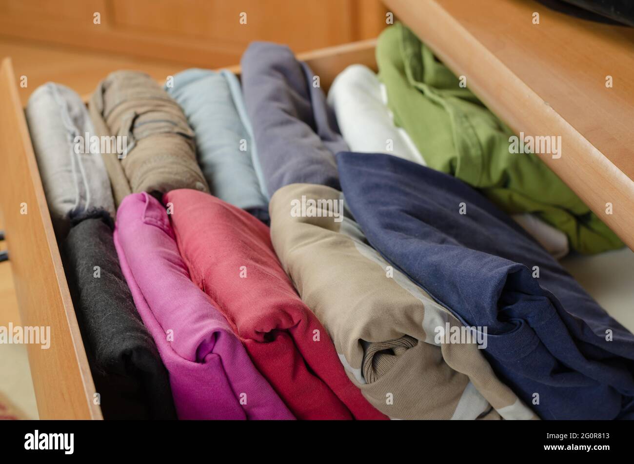 Concept Vertical Japanese clothes storage system. Multicolored shirts ...