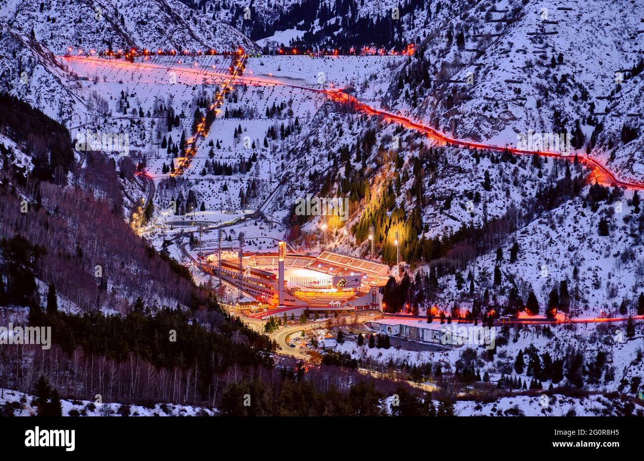 Almaty, Kazakhstan - February 19, 2021: Medeo valley with a mudflow dam and an ice skating rink of the same name at twilight Stock Photo