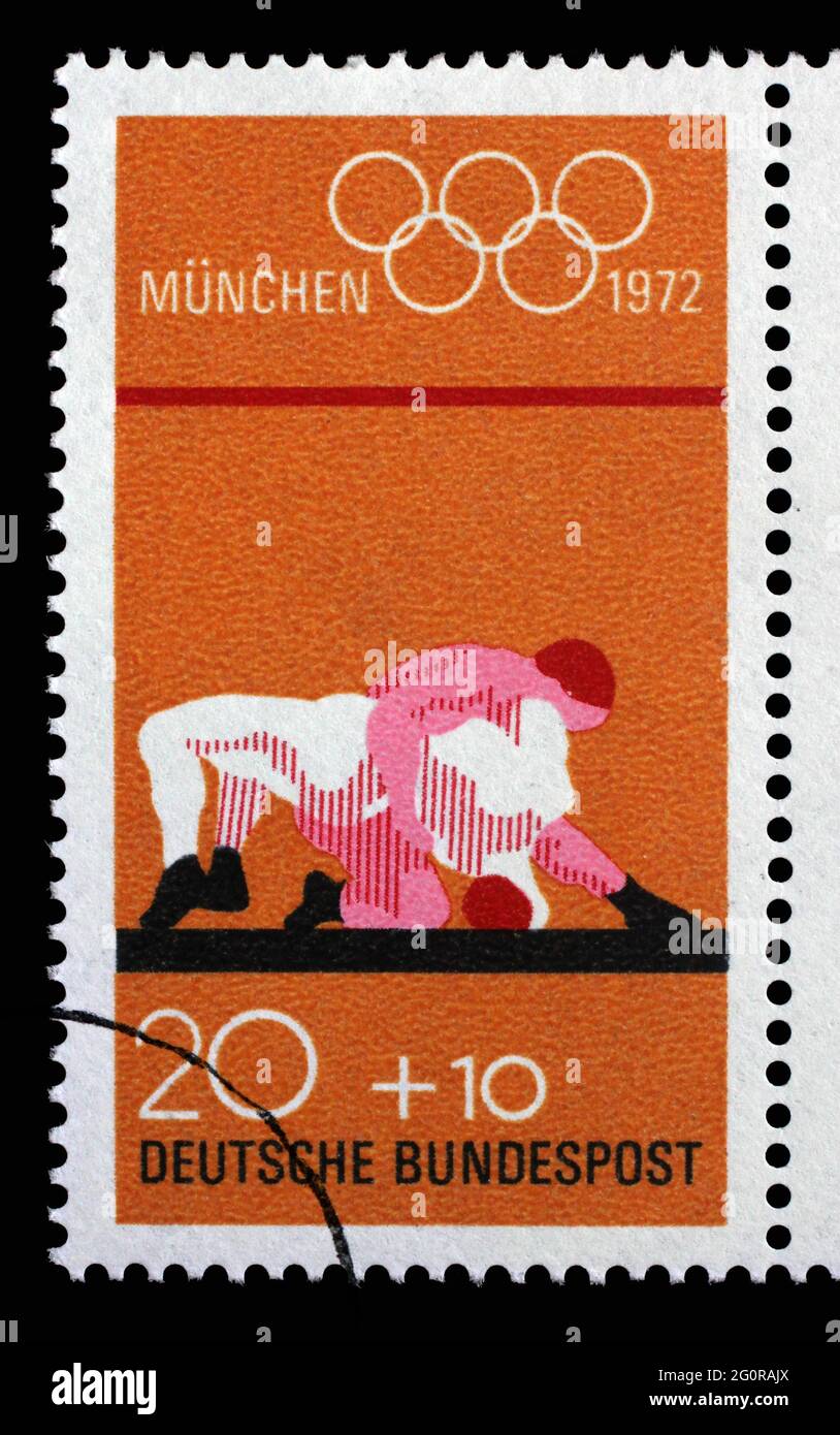 Stamp printed in Germany shows Wrestling and Olympic Rings, Summer