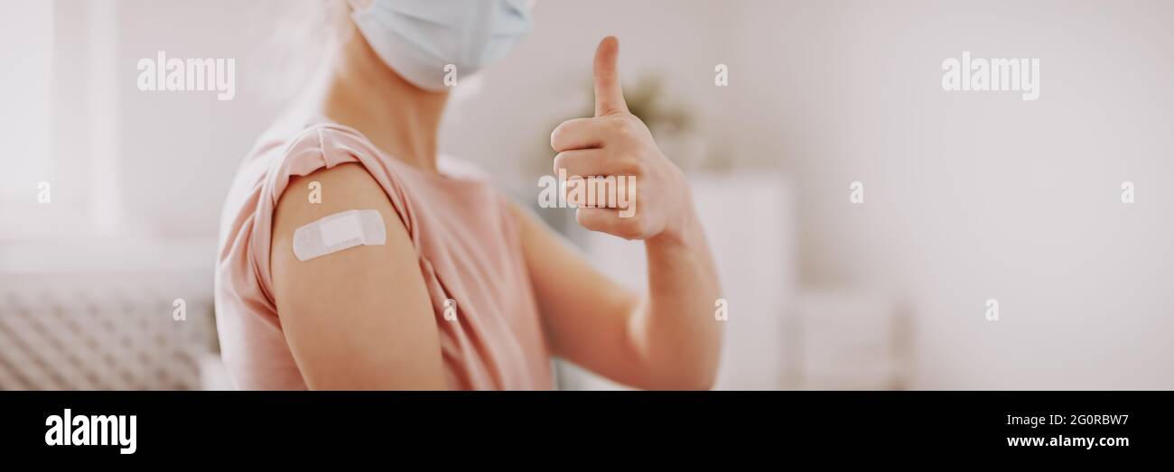 Woman showing thumb up after inoculation against Covid 19. Stock Photo