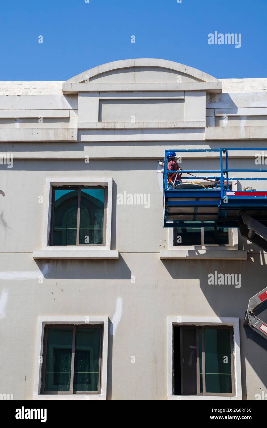 Shot of a maintenance workers working at heights, repairing facade of the building Stock Photo