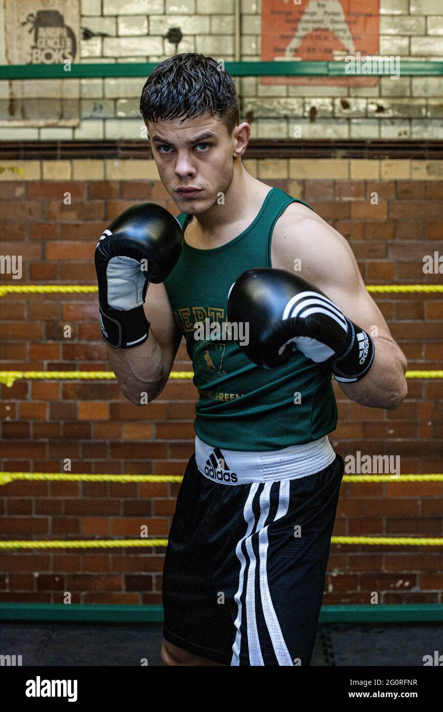 Young athletic man preparing for boxing competitions, training defense