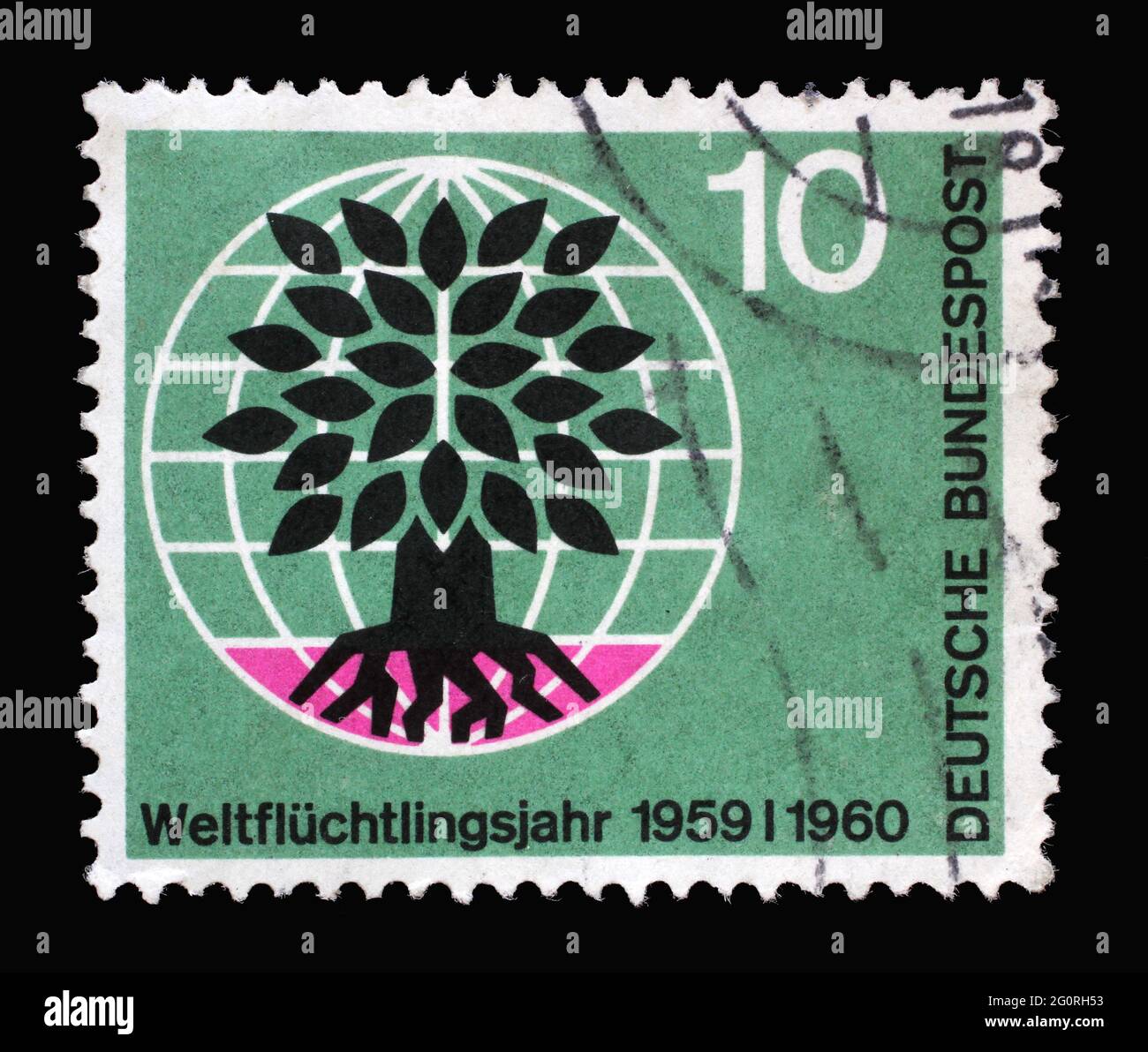 Stamp printed in Germany showing a stylized tree in a globe. World Refugee Year, circa 1960 Stock Photo