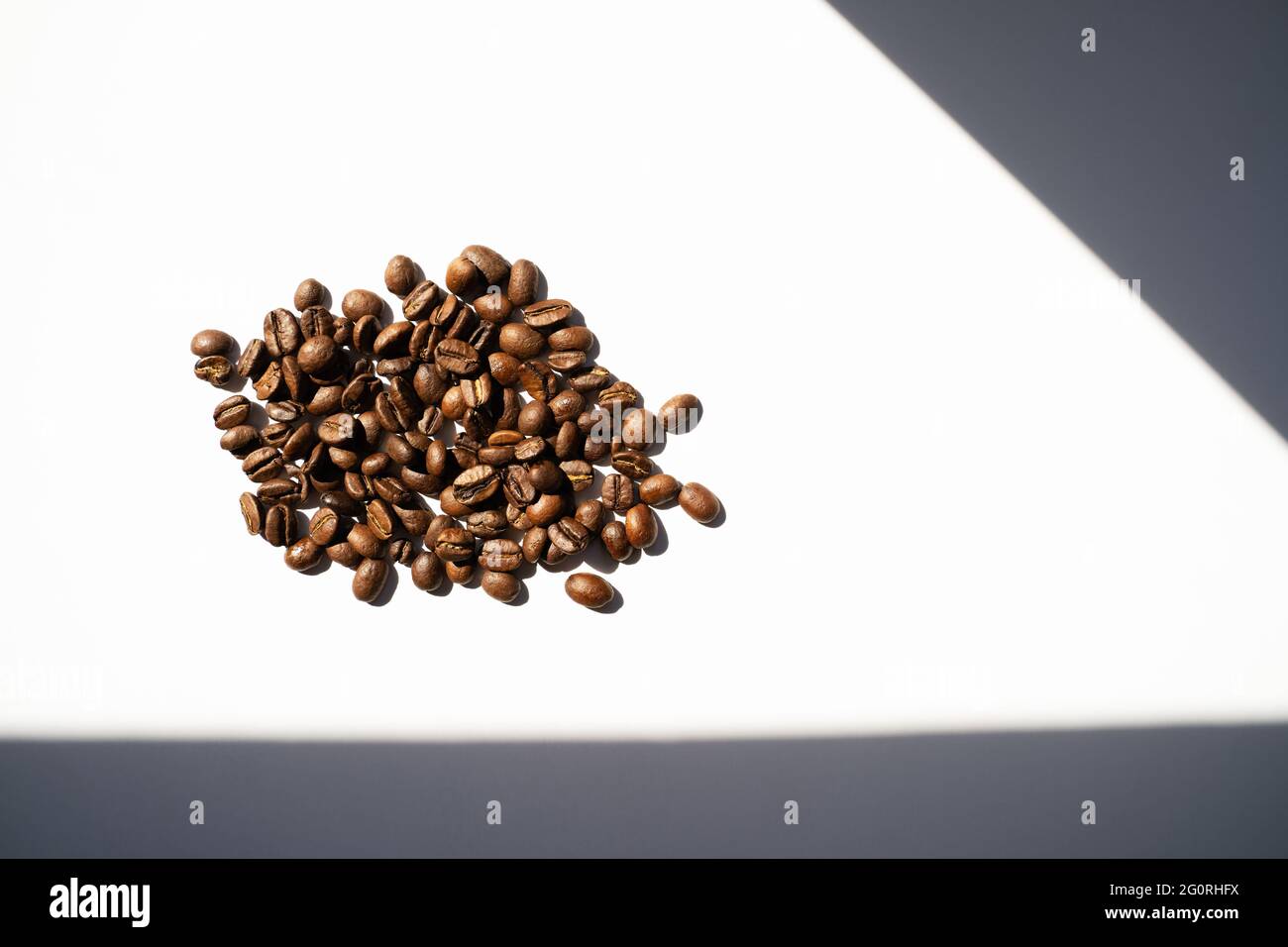 Isolated roasted coffee beans in harsh light. White background top view ...