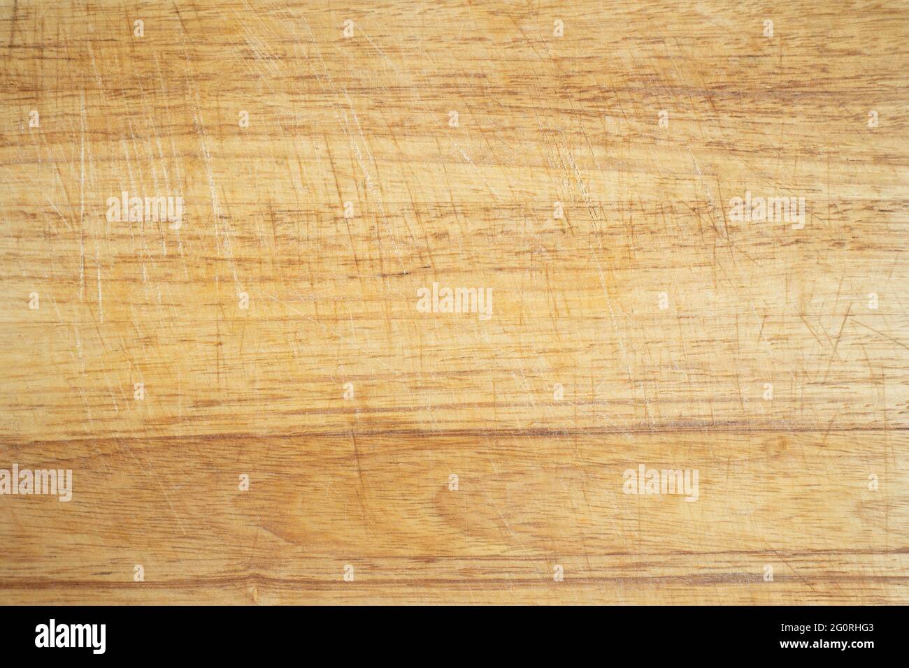 Used wooden kitchen cutting board background with trases of use cuts