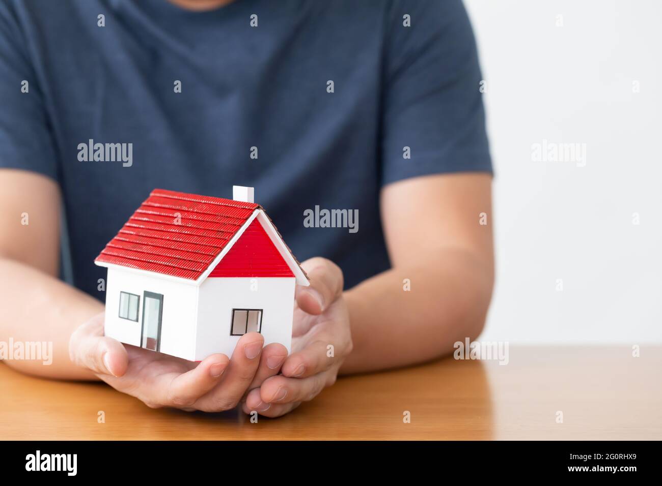 Man hands holding model of dream house Stock Photo - Alamy