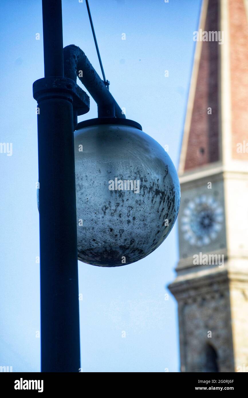 old lamp against the sky and the cathedral bell tower in the background Stock Photo