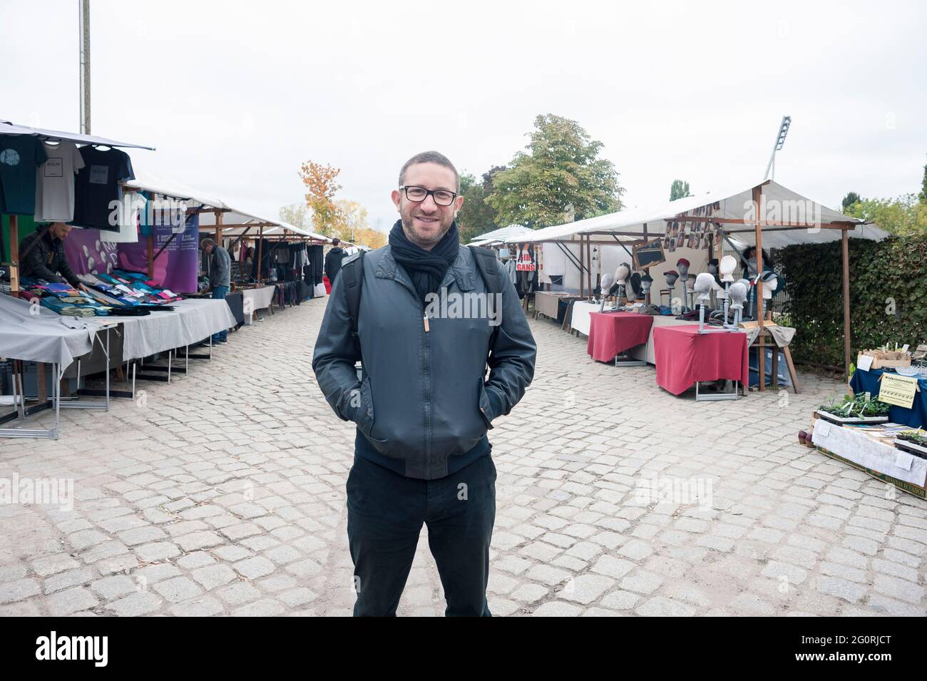 A man stands in a flea market in the german capital of berlin at the weekend. Stock Photo