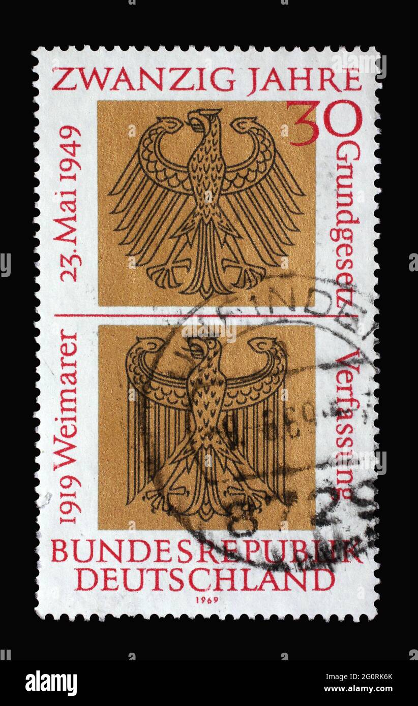 Stamp printed in Germany showing Heraldic Eagles of Federal and Weimar Republics, 20th anniversary German Basic Law and 50th anniversary the proclamat Stock Photo