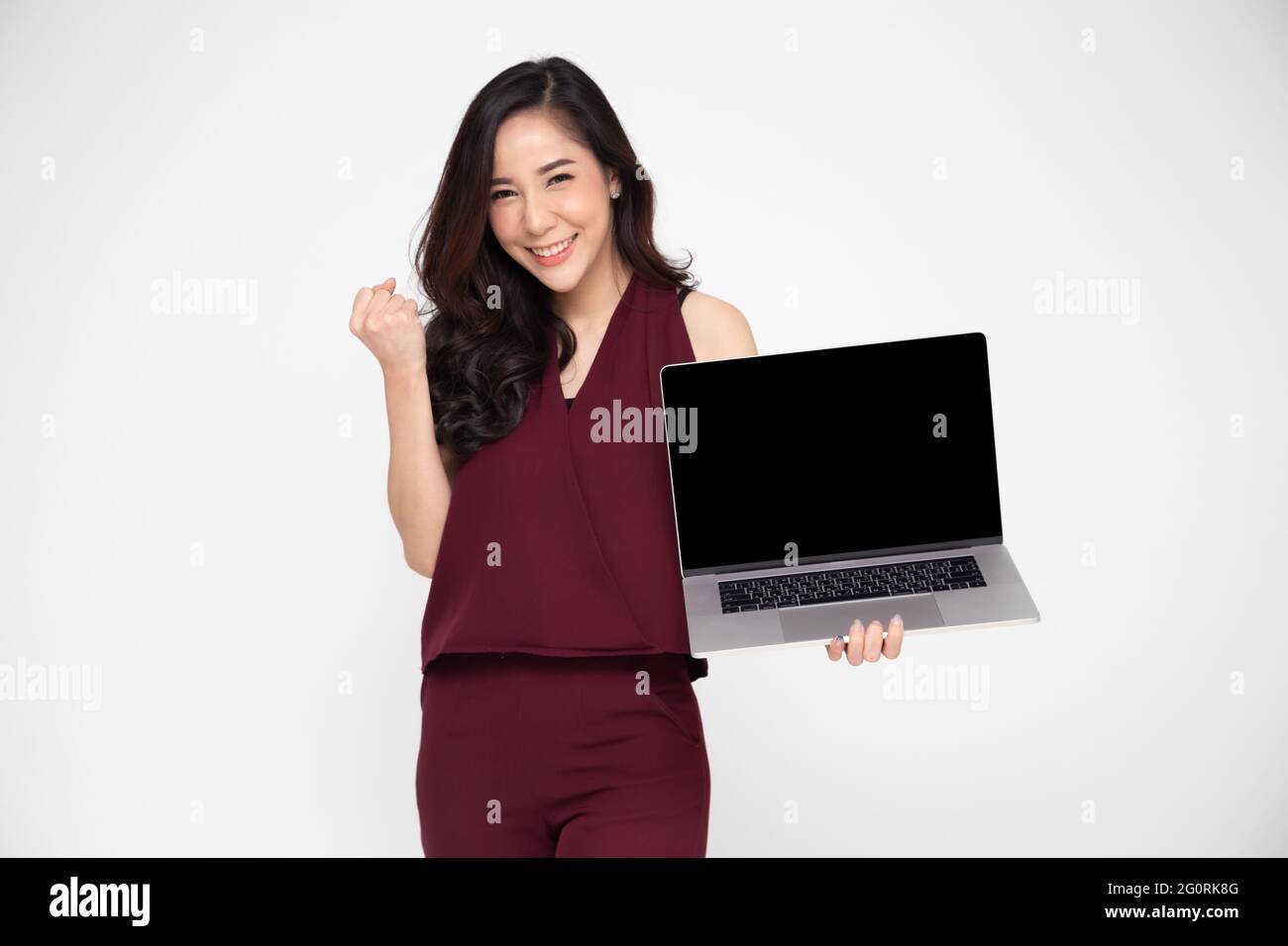 Portrait of an excited Asian woman holding laptop computer and ...