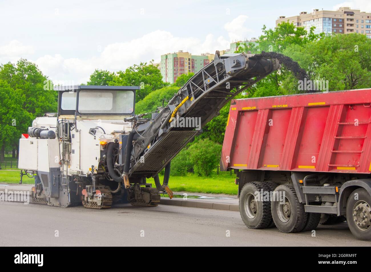 Road cold milling machine removes the old asphalt and loading into a dump truck. Repair of