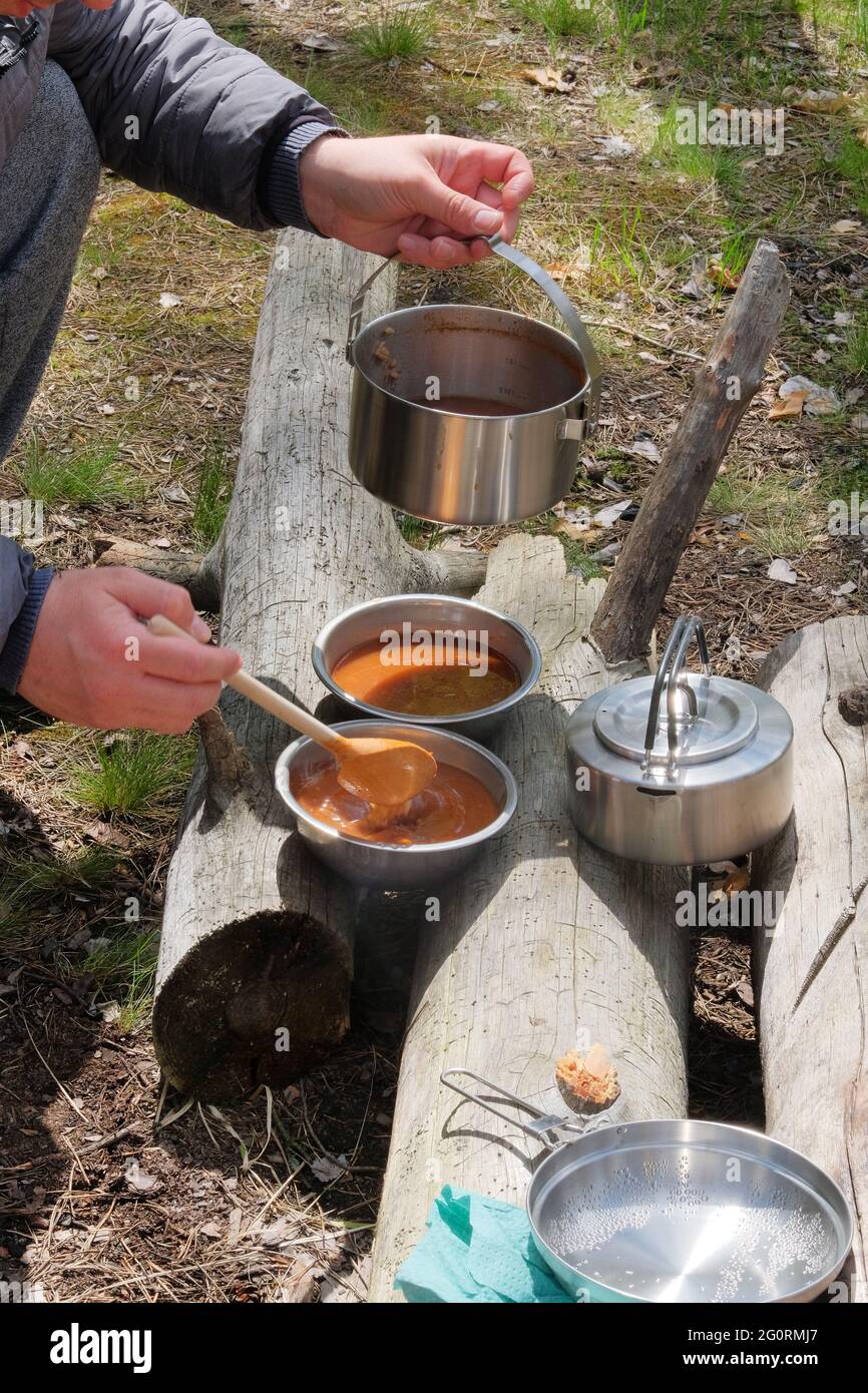 Tourist food for outdoor activities. Soup in bowls on wooden logs in