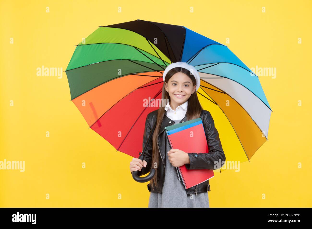 happy teen girl under colorful umbrella in autumn season hold notebook, education. Stock Photo