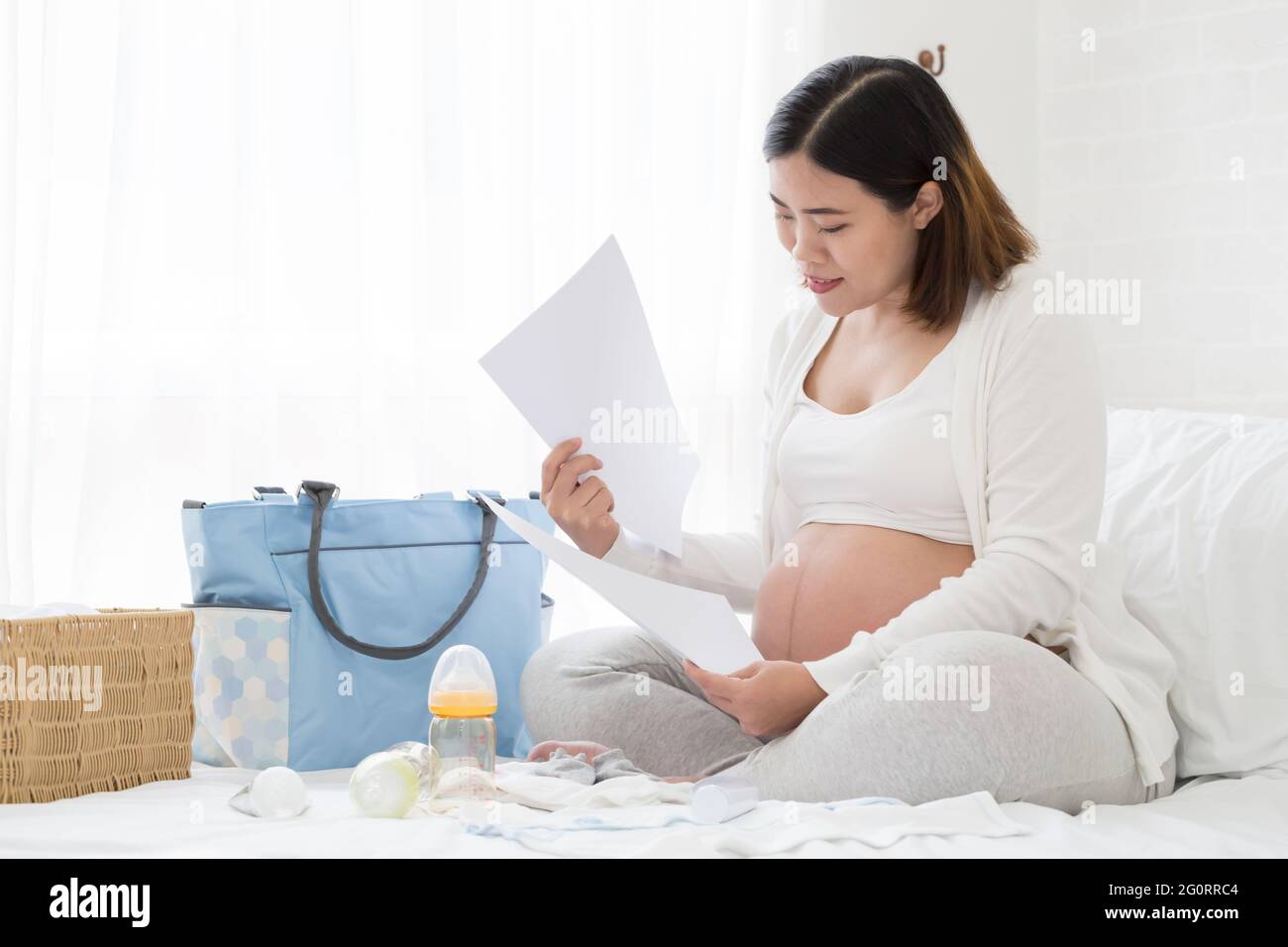 pregnant woman preparing and planning baby products before prenatal Stock Photo